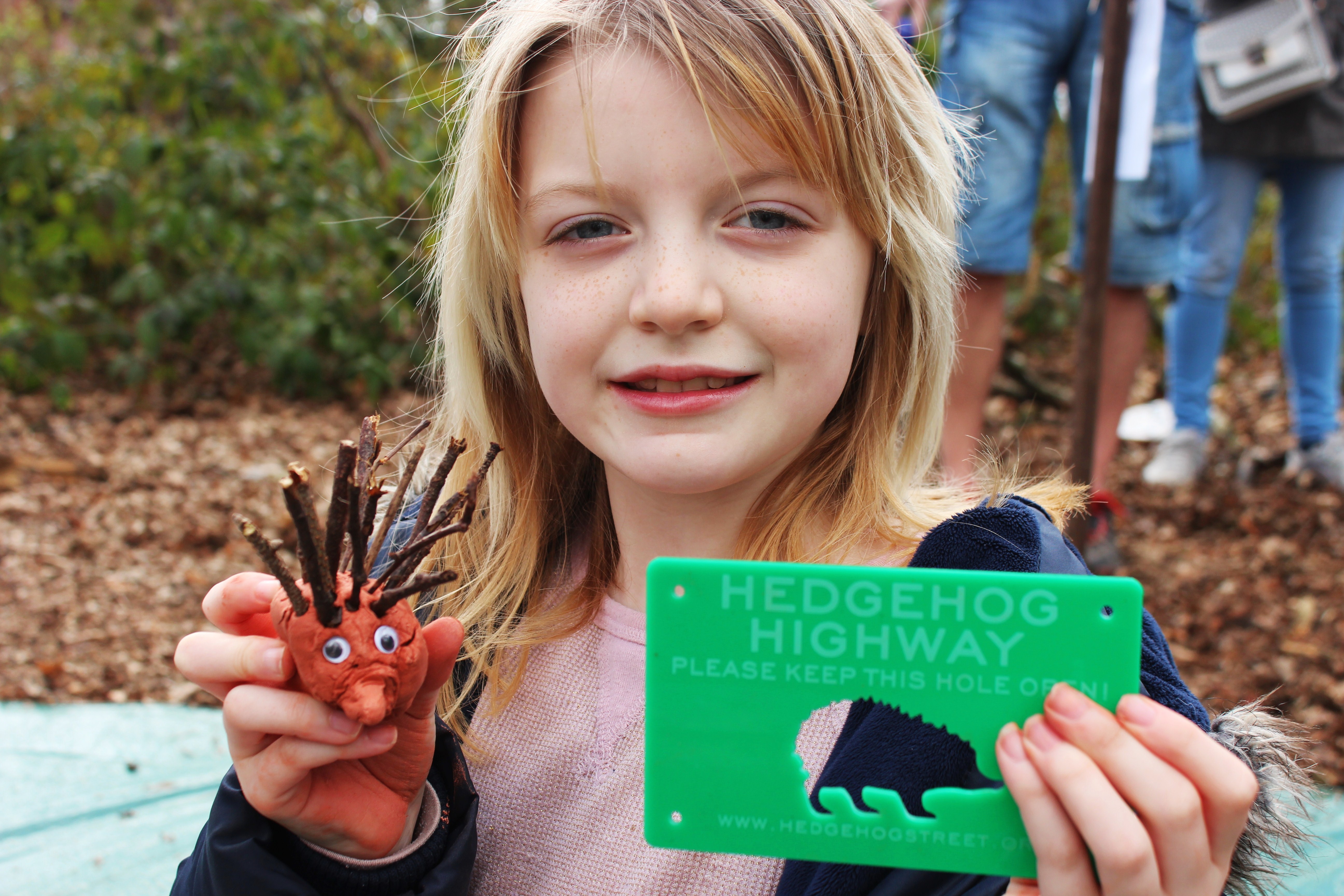 Brooke holding one of our cool Hedgehog Highway signs, available from PTES and BHPS online shops...